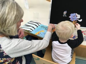 Family reads book Wheels on the Bus by Jane Cabrara and plays with felt board