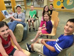 A grandma reads to grandkids and friends.